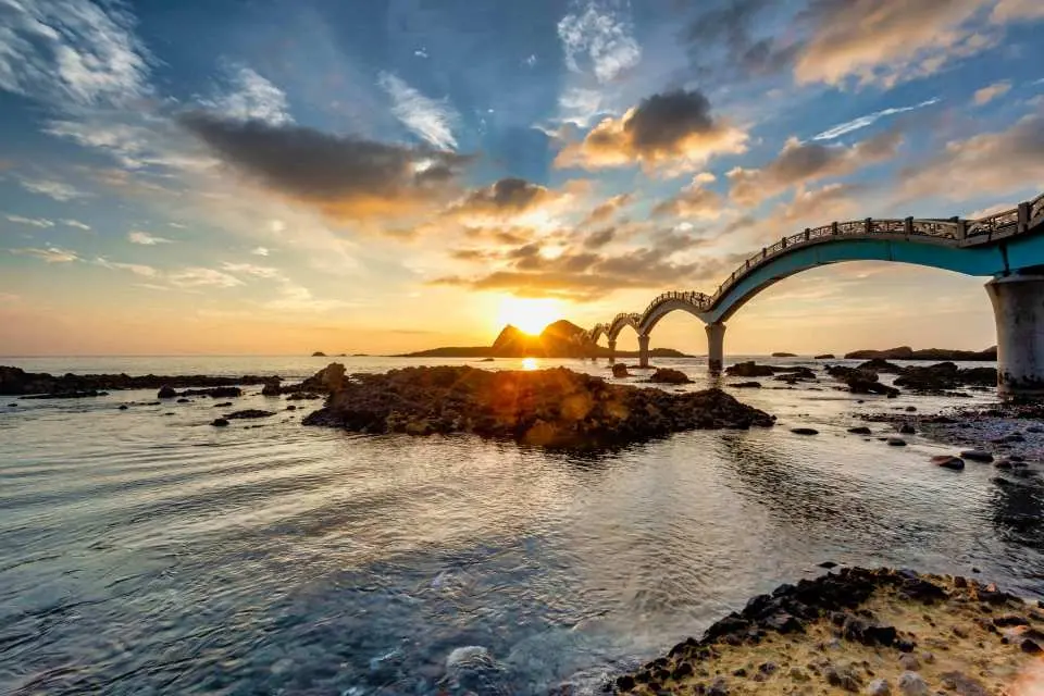 台灣台東三仙台八拱橋的壯麗日出景色，金黃光芒灑落在海上和礁岩，展現東海岸夢幻般的第一道曙光。