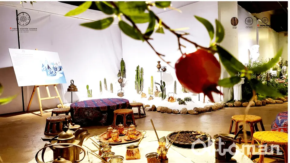 Ottoman-themed exhibition area at Vietnam's World of Coffee Museum, displaying traditional coffee sets, rugs, and desert plants, offering an immersive cultural experience.