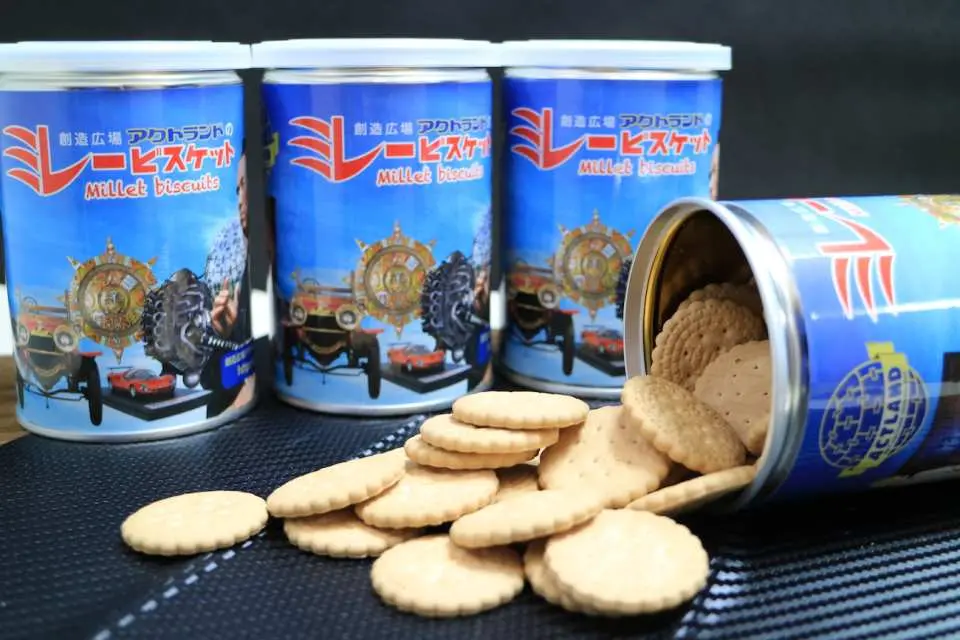 ACTLAND exclusive Millet Biscuits (ミレービスケット) cans and spilled biscuits, a special gift for 3-museum pass holders in Kochi, Japan.