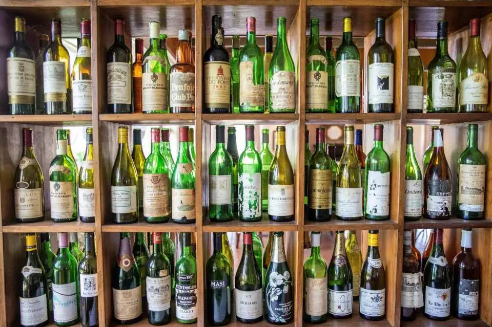 ハンターバレーのワイナリーにある木製棚に、様々な種類の高級ワインボトルが美しく陳列され、テイスティングを待っています。