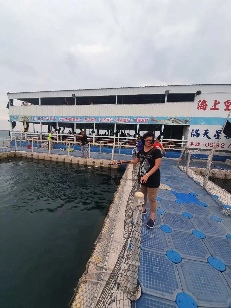 旅客在澎湖海上皇宮觀光平台旁的浮動碼頭上，準備登船體驗海洋牧場活動。