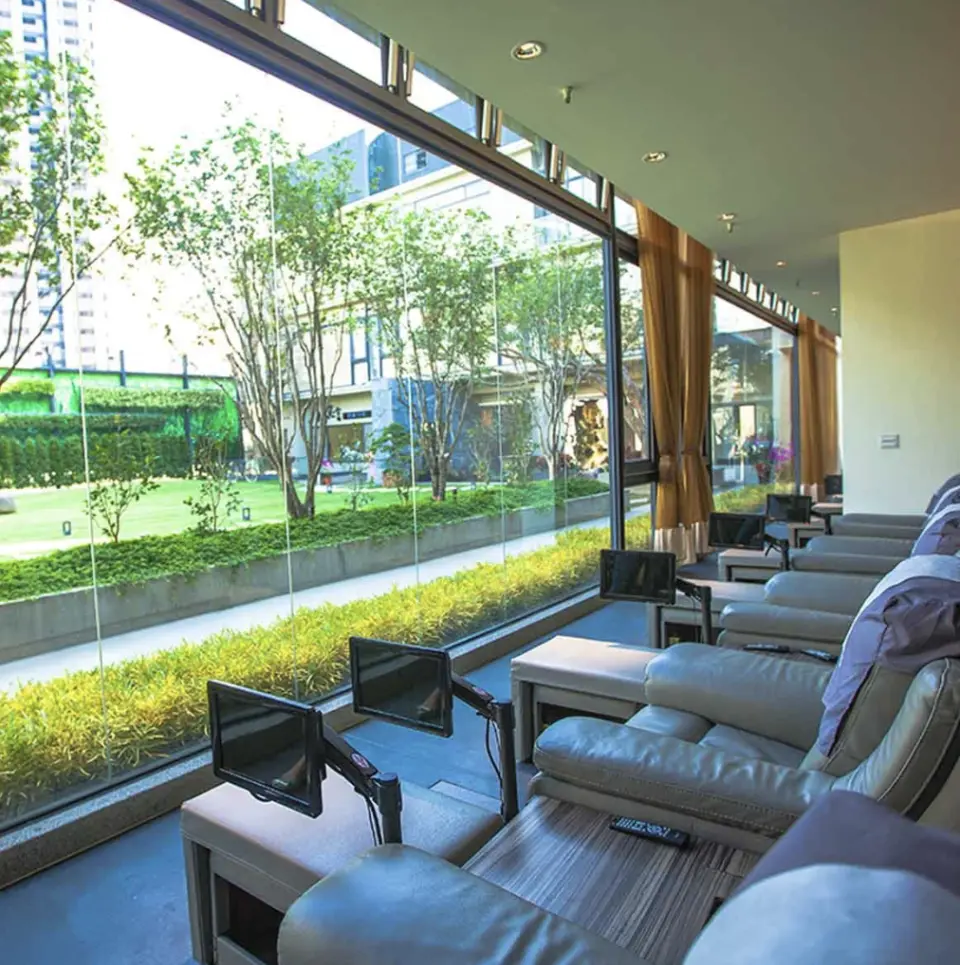 金礦928會館寬敞的腳底按摩區，落地窗外綠意盎然，配備電動沙發及專屬影音，提供視覺與身心雙重享受。