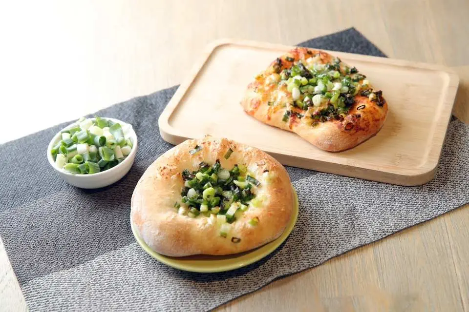 Two golden, crispy scallion pancakes with fresh chopped scallions, the delicious result of the DIY scallion pancake making activity at Star Bao Sanxing Scallion Farm, a highlight of the Yilan family half-day tour.