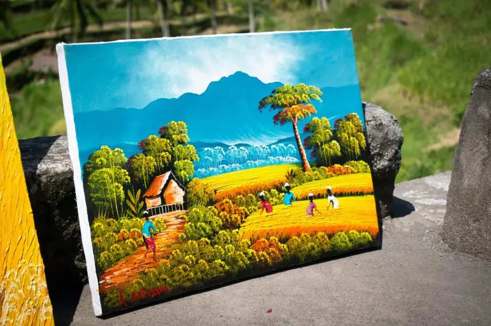 A vibrant Balinese landscape painting showcasing green rice terraces, majestic mountains, a waterfall, and local villagers, reflecting Bali's rich natural scenery and unique artistic style.