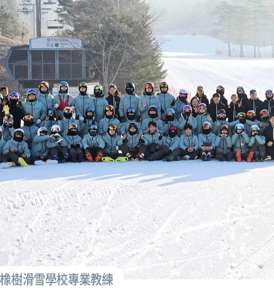 橡樹谷滑雪學校的專業教練與一大群學員在雪道上合影，背景為滑雪纜車，強調小班制課程與專業指導。