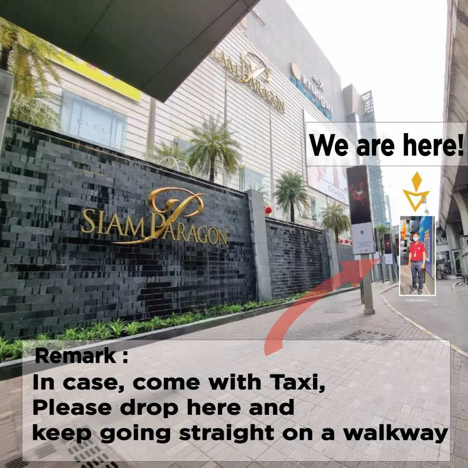 A pick-up point instruction map outside Siam Paragon department store in Bangkok, indicating the taxi drop-off and walking route for travelers joining the Kanchanaburi day trip.