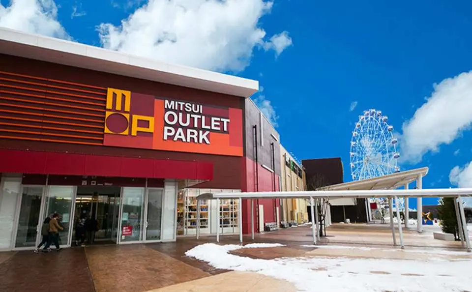 神戶三田MITSUI OUTLET PARK的主要入口，設計現代時尚，旁邊隱約可見摩天輪，為購物體驗增添樂趣。