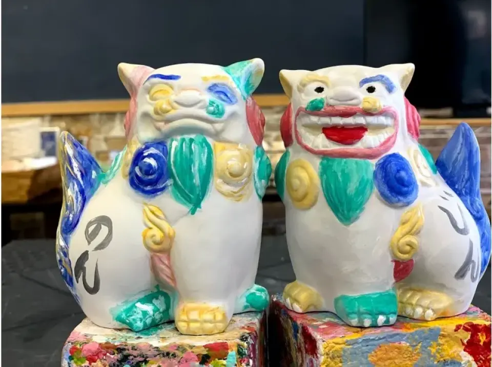 Hai bức tượng thần hộ mệnh Shisa Okinawa được vẽ sáng tạo, thể hiện các thiết kế đa sắc màu rực rỡ với tông màu pastel, phản ánh sự biểu đạt nghệ thuật cá nhân.