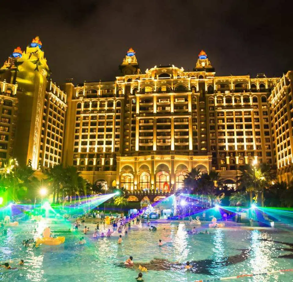 夜晚的長隆橫琴灣酒店，戶外水上樂園被繽紛燈光照亮，遊客在泳池中暢玩，享受熱鬧的夜間娛樂。