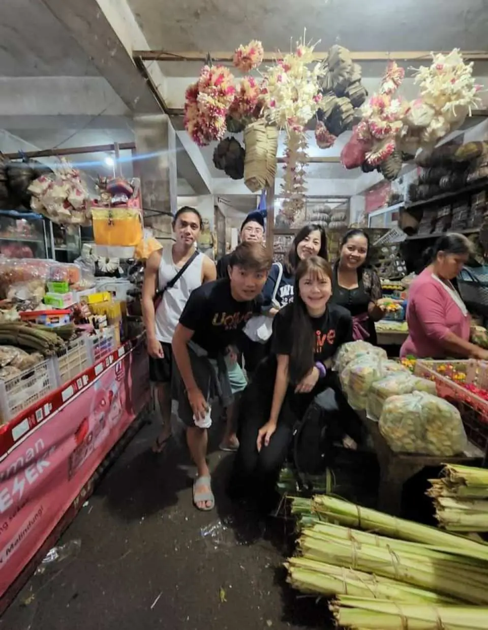 Ubud cooking class participants happily explore a bustling traditional Balinese market, experiencing the joy of sourcing fresh ingredients and deeply immersing themselves in local culture.