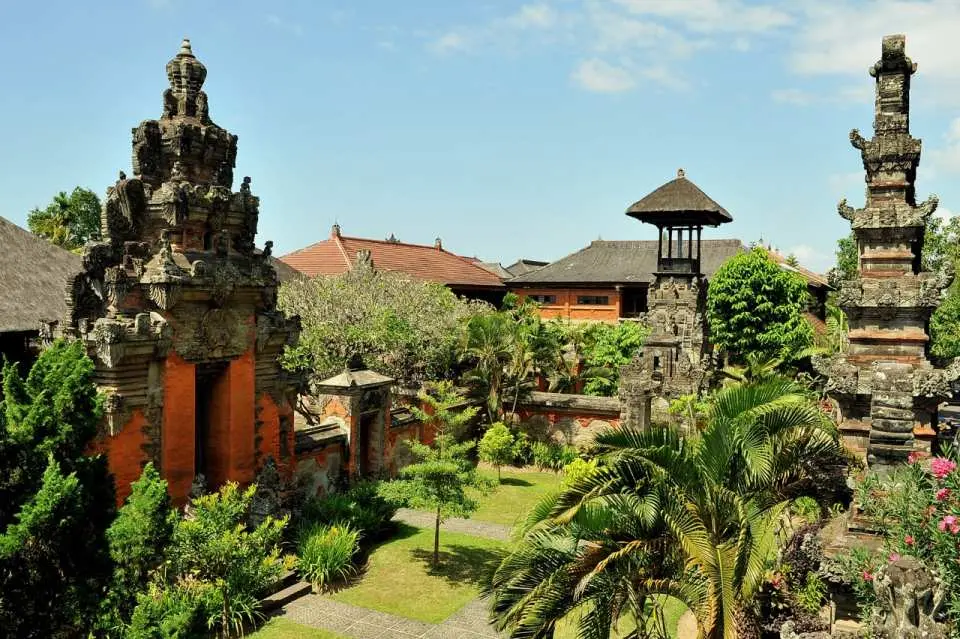 Serene courtyard of the Bali Museum in Denpasar, showcasing traditional Balinese architecture, ornate stone gates, lush tropical plants, and tranquil pathways for cultural exploration.