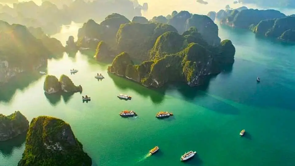 Breathtaking panoramic view of Halong Bay at sunset or sunrise, showcasing its numerous limestone karsts and emerald waters, a New Seven Wonders of Nature.