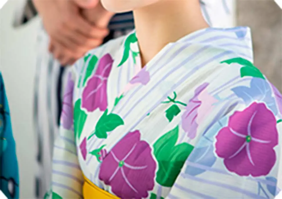 후쿠오카 하카타 유카타 대여. 보라색 나팔꽃과 녹색 잎사귀 패턴이 인쇄된 흰색 유카타와 눈에 띄는 노란색 오비의 클로즈업.