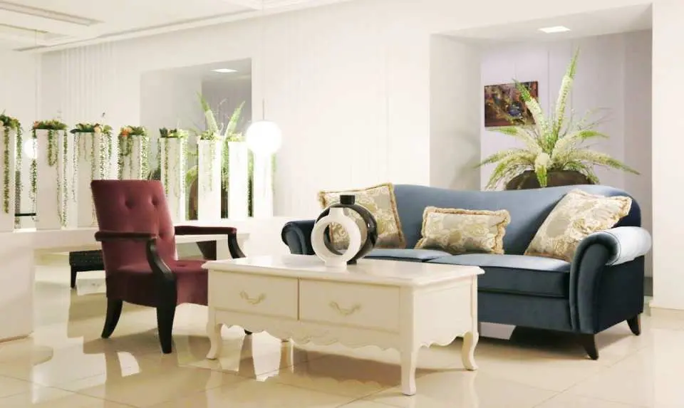 Elegantly designed VIP lounge at Taipei's Royal Spa, offering a comfortable blue sofa, armchairs, and greenery, creating a relaxing waiting space for guests.