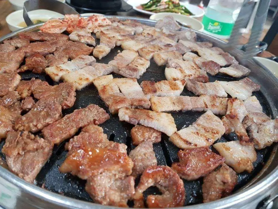 韓國特色三式燒肉任食晚餐，烤盤上 sizzling 的豬五花和不同肉品，香氣四溢，令人食指大動。