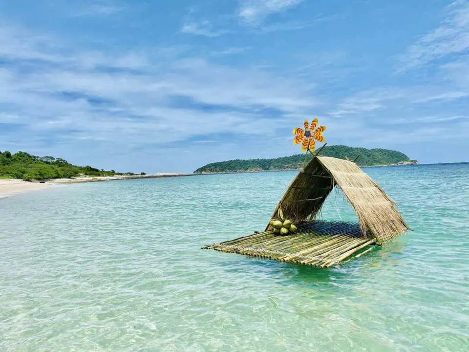 A charming Thai bamboo raft hut floating in the shallow waters off Pai Island, offering a tropical and relaxing ambiance for the Pattaya private speedboat tour experience.