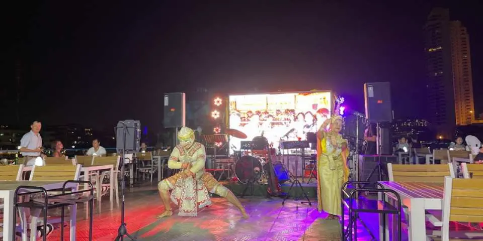 An exciting traditional Thai dance performance on the Smile Riverside cruise ship's deck, with dancers in elaborate costumes offering guests a unique cultural and artistic feast.