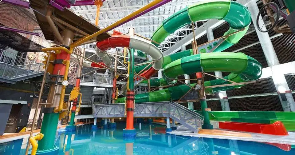 Panoramic view of HomeTeamNS Bedok Reservoir Aqua Adventure indoor water park in Singapore, showcasing multiple colorful water slides and challenging facilities for family fun.