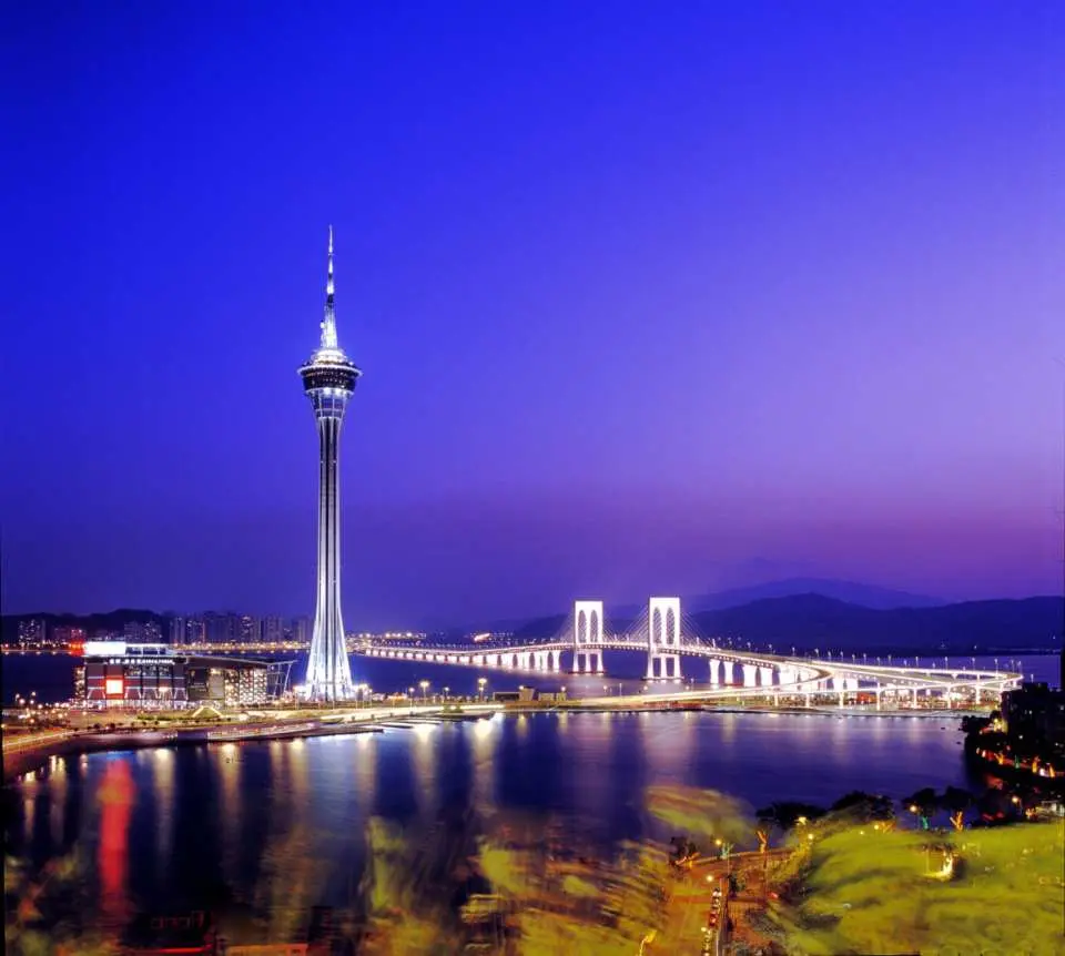 The iconic Macau Tower and Governador Nobre de Carvalho Bridge brilliantly lit at night, showcasing Macau's stunning urban landscape.