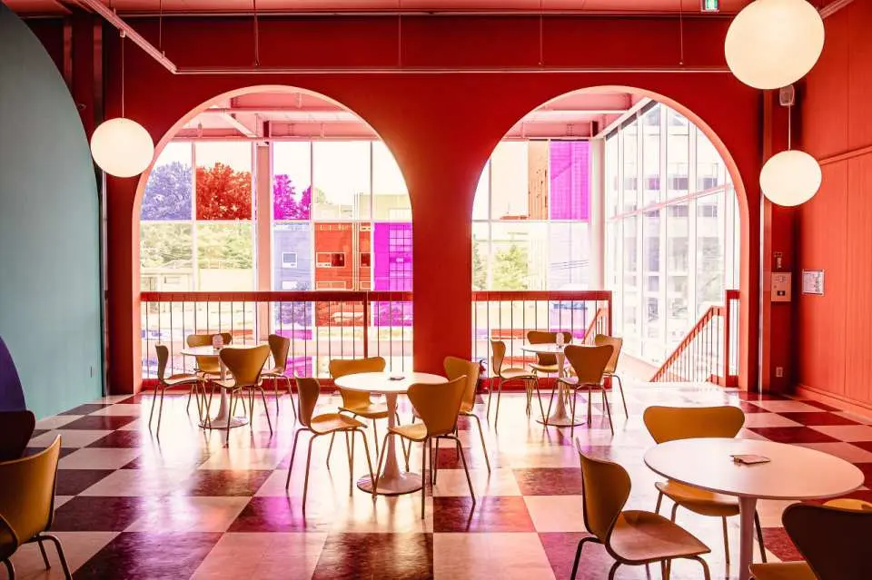 韩国坡州特色打卡咖啡店的用餐区，棋盘格地板、彩色玻璃拱窗，充满几何美学与艺术感。