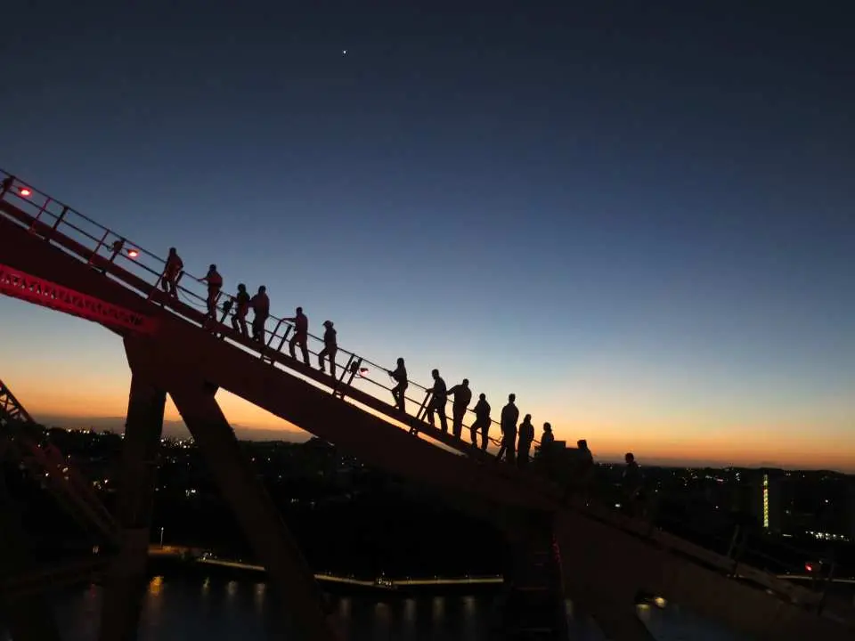 Climbers silhouetted on Brisbane's Story Bridge against a gradient dawn or dusk sky, capturing the unique moment of a sunrise or sunset climb experience.