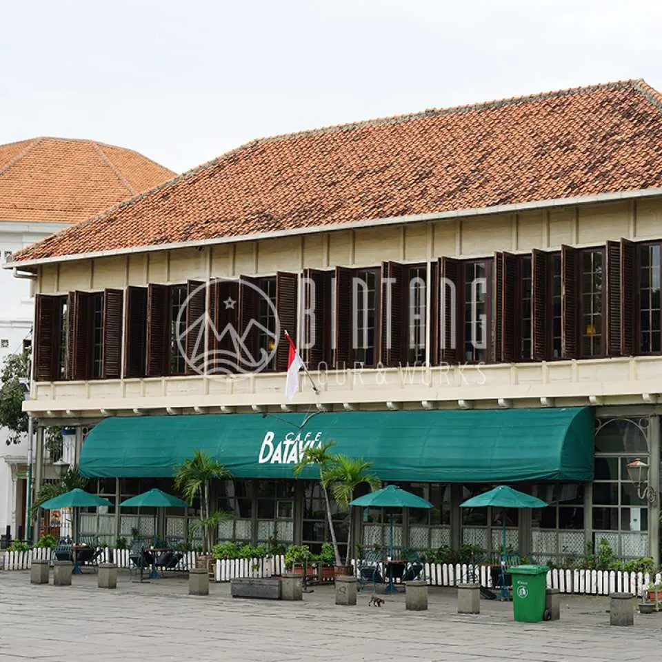 雅加达旧城区标志性的巴达维亚咖啡馆，一座保存完好的殖民建筑，拥有独特的绿色遮阳篷和迷人的户外座位，非常适合历史悠久的用餐体验。