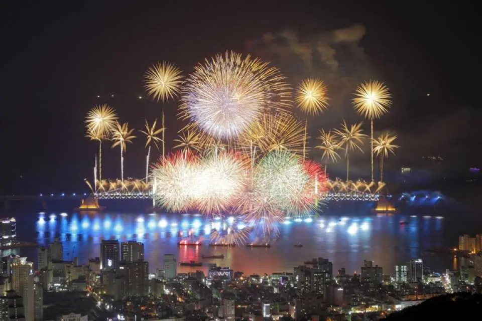 広大な釜山海岸線の夜景。広安大橋上空では多様な花火とレーザーショーが輝き、釜山国際花火大会の素晴らしい光景を演出しています。