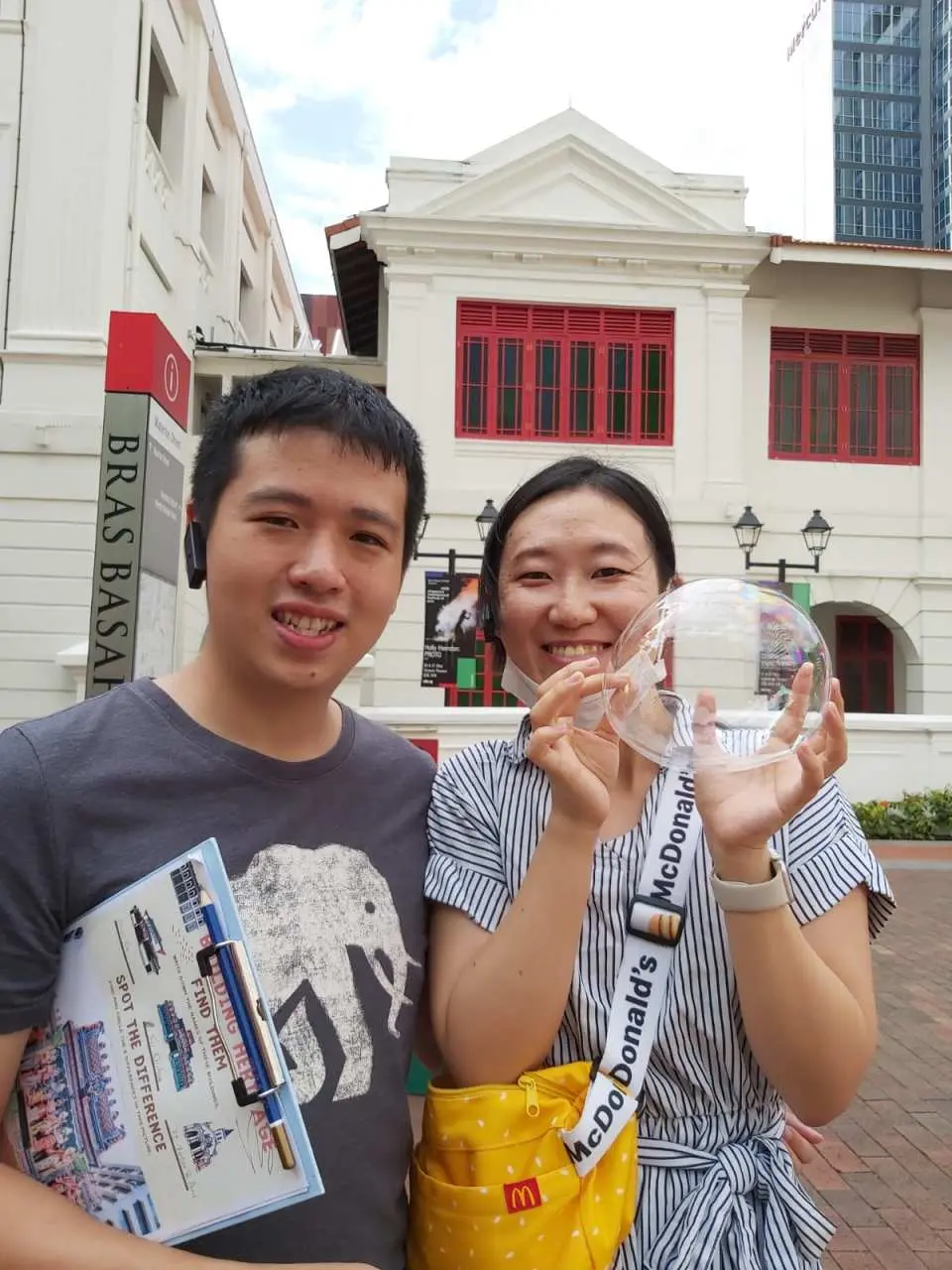 Happy participants posing with a clear spherical prize and a map outside a beautiful colonial building during the Bugis heritage hunt, showcasing the fun and discovery of the tour.