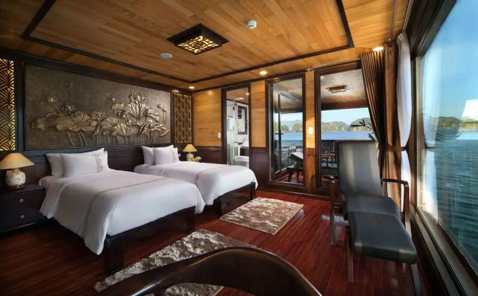 The V'Spirit cruise's luxurious sea-view twin cabin, adorned with traditional Vietnamese art, offers travelers comfortable and culturally rich accommodation in Halong Bay's Lan Ha Bay.