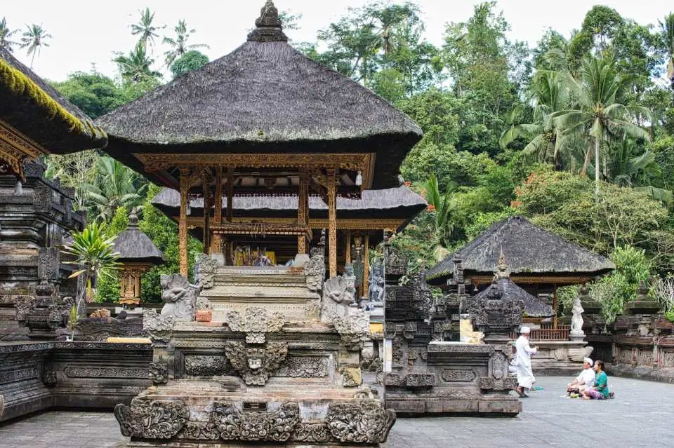 巴厘岛圣泉寺雄伟的传统建筑，展示其独特的印度教曼荼罗设计，周围环绕着茂密的 C 热带植物。