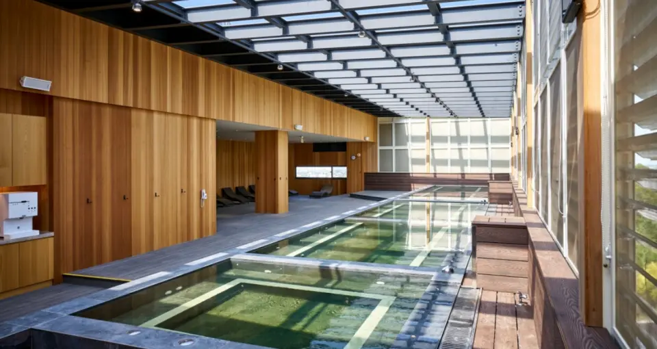 苗栗享沐時光莊園渡假酒店寬敞明亮的室內溫泉設施，設有多個溫泉池和木質休憩區，透過透明屋頂引入自然光線，營造舒適泡湯體驗。