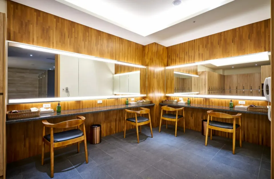 苗栗享沐時光莊園渡假酒店設計時尚的更衣梳妝區，設有寬敞明亮的鏡面、獨立座位與洗手台，提供泡湯前後的舒適準備空間。