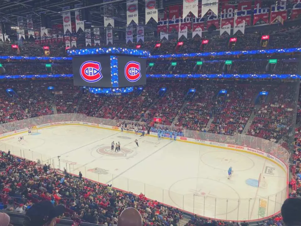 Experience the thrill of a Montreal Canadiens NHL hockey game at Bell Centre, with passionate fans cheering and the team logo displayed on the large screen.