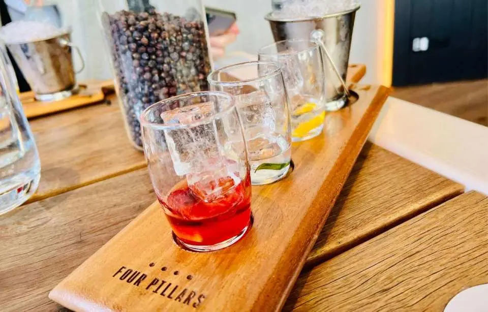 Four Pillars Gin Distillery tasting paddle, displaying three unique gins or gin cocktails with ice and lemon slices.