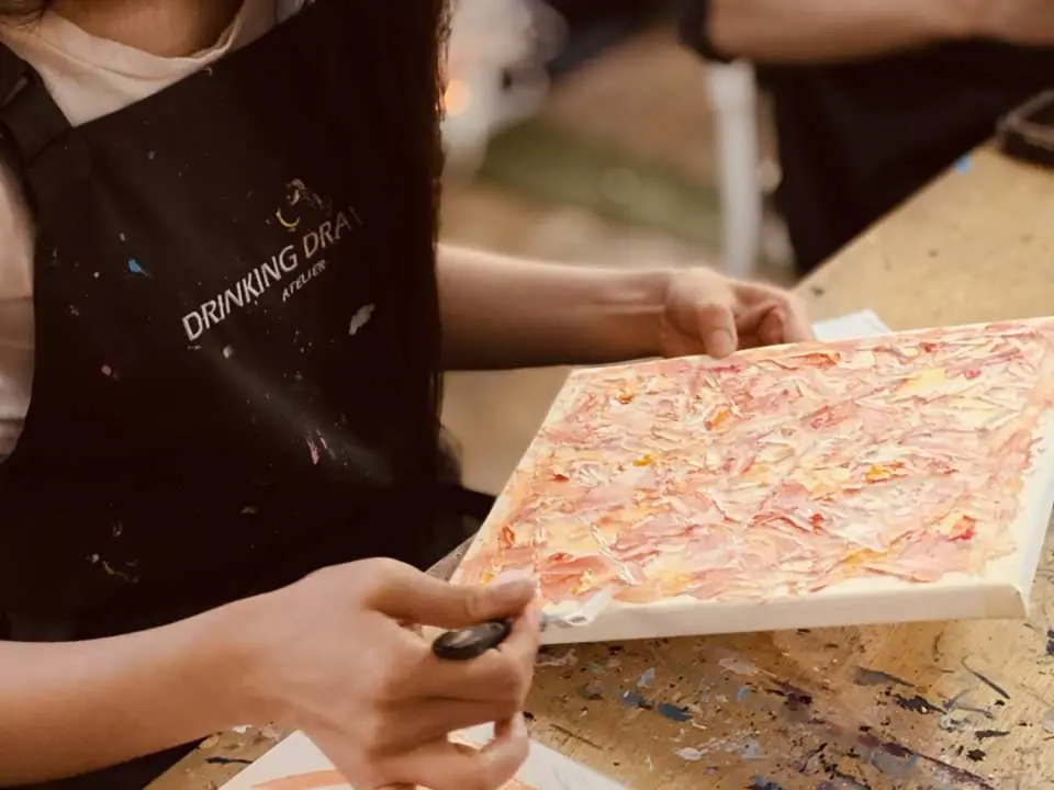 서울 잠실 아크릴화 원데이 체험에서 수강생이 앞치마를 입고 나이프로 질감 있는 추상화를 집중하여 그리며, 그림 그리는 즐거움을 만끽합니다.