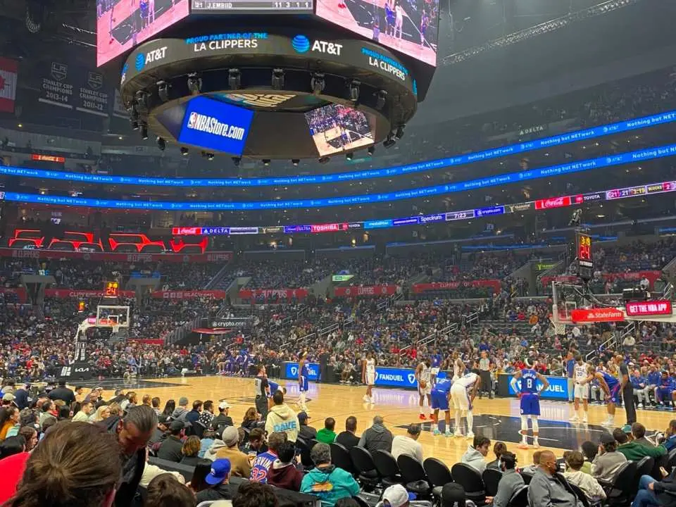 Close-up view of a Los Angeles Clippers NBA basketball game from the lower stands at Crypto.com Arena, feeling the intense competition and electrifying atmosphere with players and fans nearby.