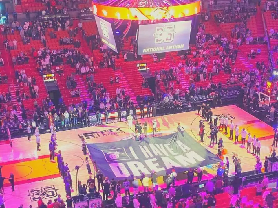 邁阿密熱火隊主場卡西雅中心NBA特別賽事現場，球員們列隊在球場上，中央展示著「I HAVE A DREAM」的紀念橫幅。