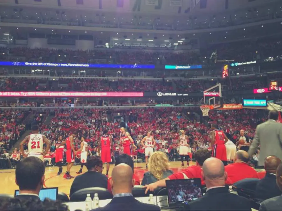 Courtside view of a Chicago Bulls NBA game at United Center, offering a thrilling close-up perspective of players competing on the basketball court and the intense game action.