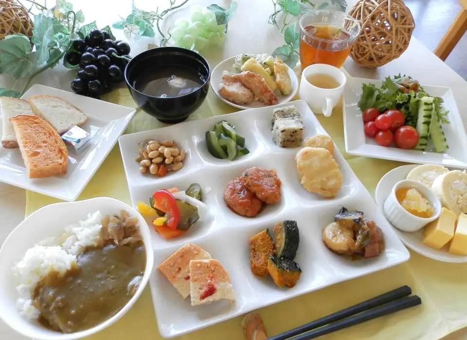 “云上葡萄”餐厅的精致自助餐点特写，包含日式咖喱饭、新鲜沙拉、炸物与多样小菜，满足旅客味蕾。