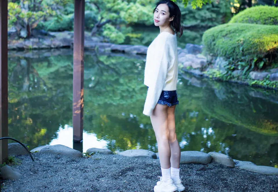 仙台日式庭園個人寫真快照，女性在綠意盎然的池塘邊優雅擺拍，捕捉寧靜之美。