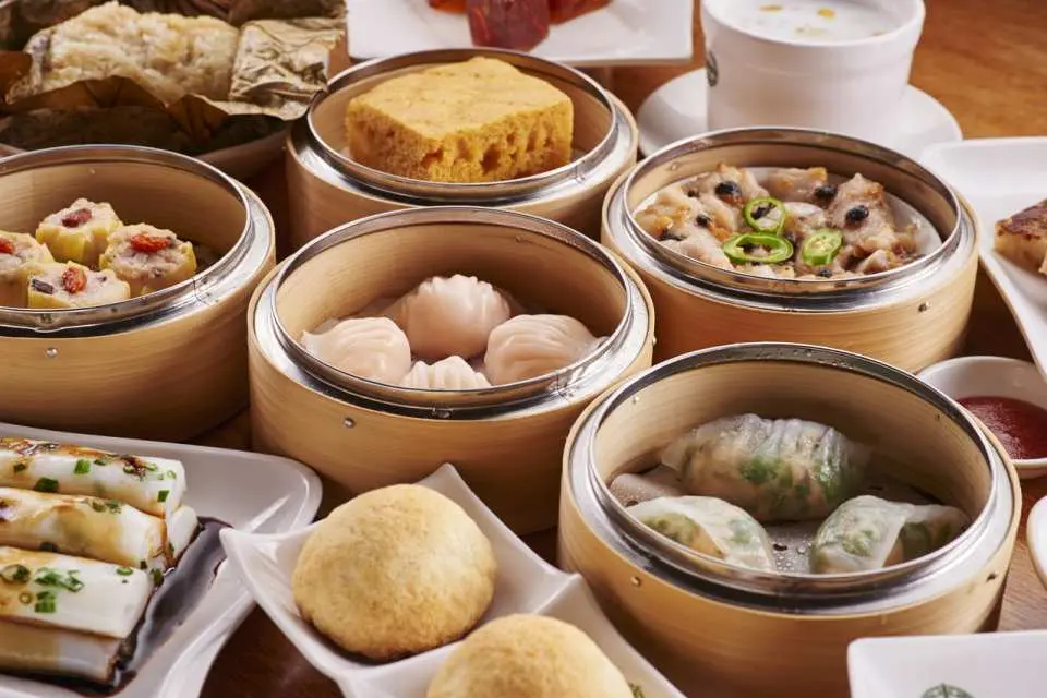 An appetizing spread of Michelin-starred Tim Ho Wan Cantonese dim sum, featuring har gow, siu mai, and char siu bao, showcasing authentic Hong Kong culinary delights.