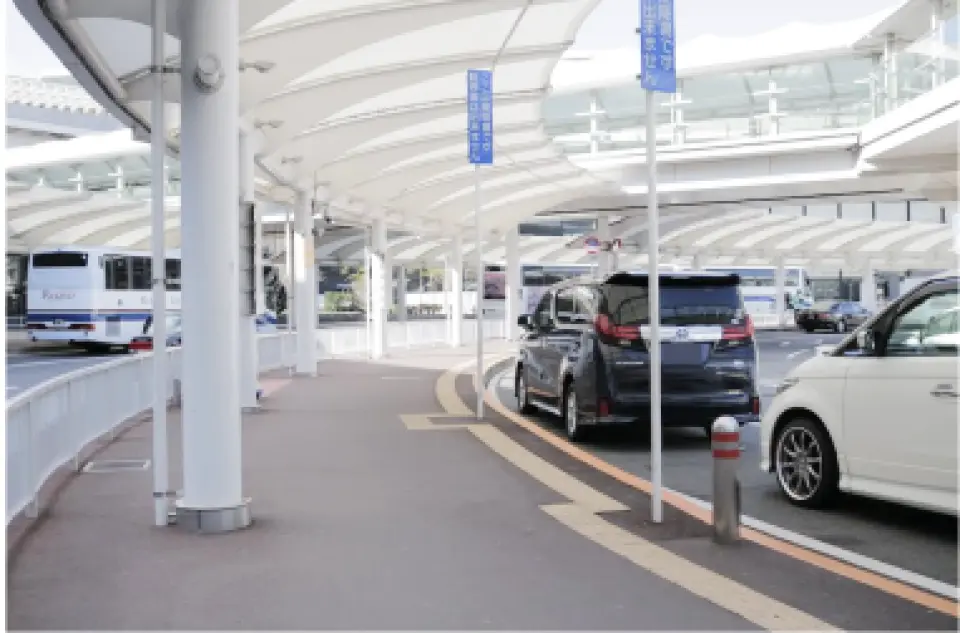 A spacious outdoor transfer waiting area at Tokyo Airport, featuring multiple luxury vehicles parked, ensuring a comfortable and convenient boarding experience for travelers.