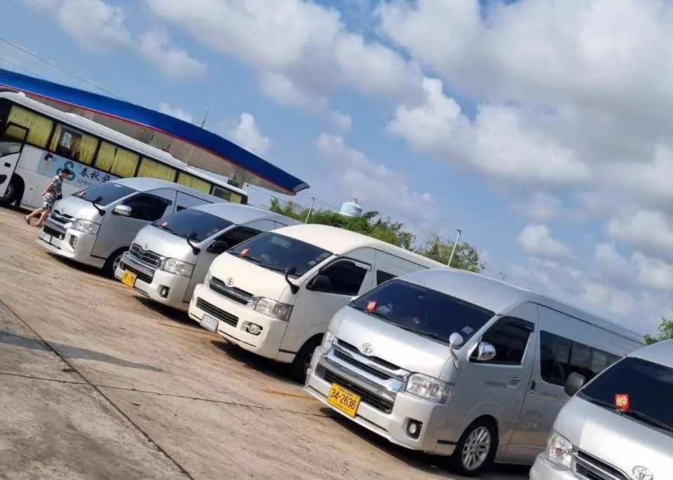 A fleet of white minivans providing Pattaya hotel pickup and drop-off service, ensuring convenient and comfortable travel for visitors to the Koh Samet day trip meeting point or back to their hotel.