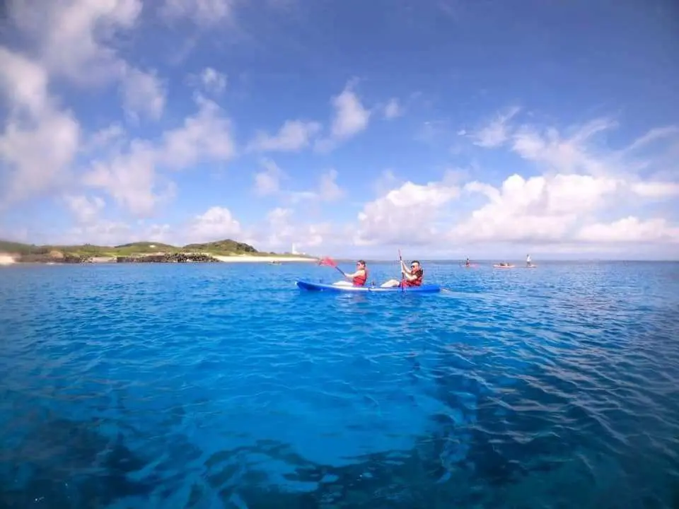 綠島四合一水上活動，兩位遊客在湛藍清澈的海域中划獨木舟，感受綠島的自然魅力。