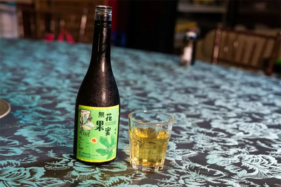 澳门土生葡菜烹饪体验中，桌上摆放着特色无花果酒，搭配精致酒杯，展现葡国饮食文化与独特风味。