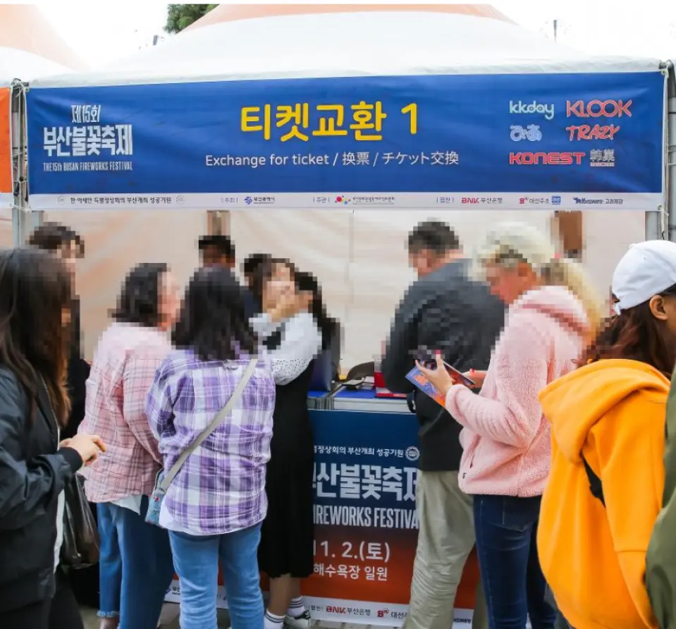 2025釜山煙火節的票券交換處，人們排隊準備領取預訂門票，準備觀賞一年一度的盛會。