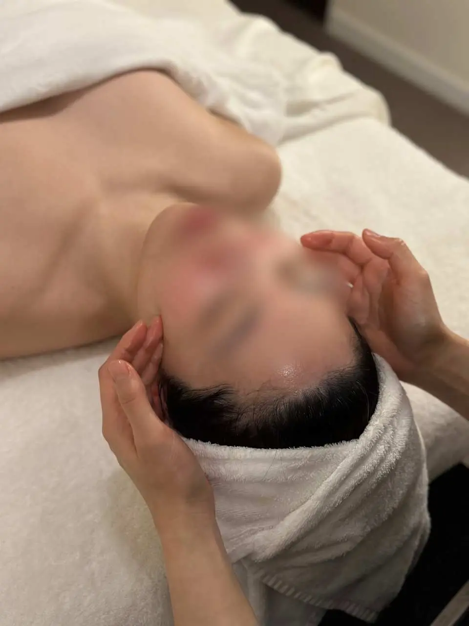 A close-up of a professional facial treatment at THE FORET SPA Seongsu in Seoul, where an aesthetician provides a meticulous massage, offering premium skincare and a deeply relaxing spa experience.