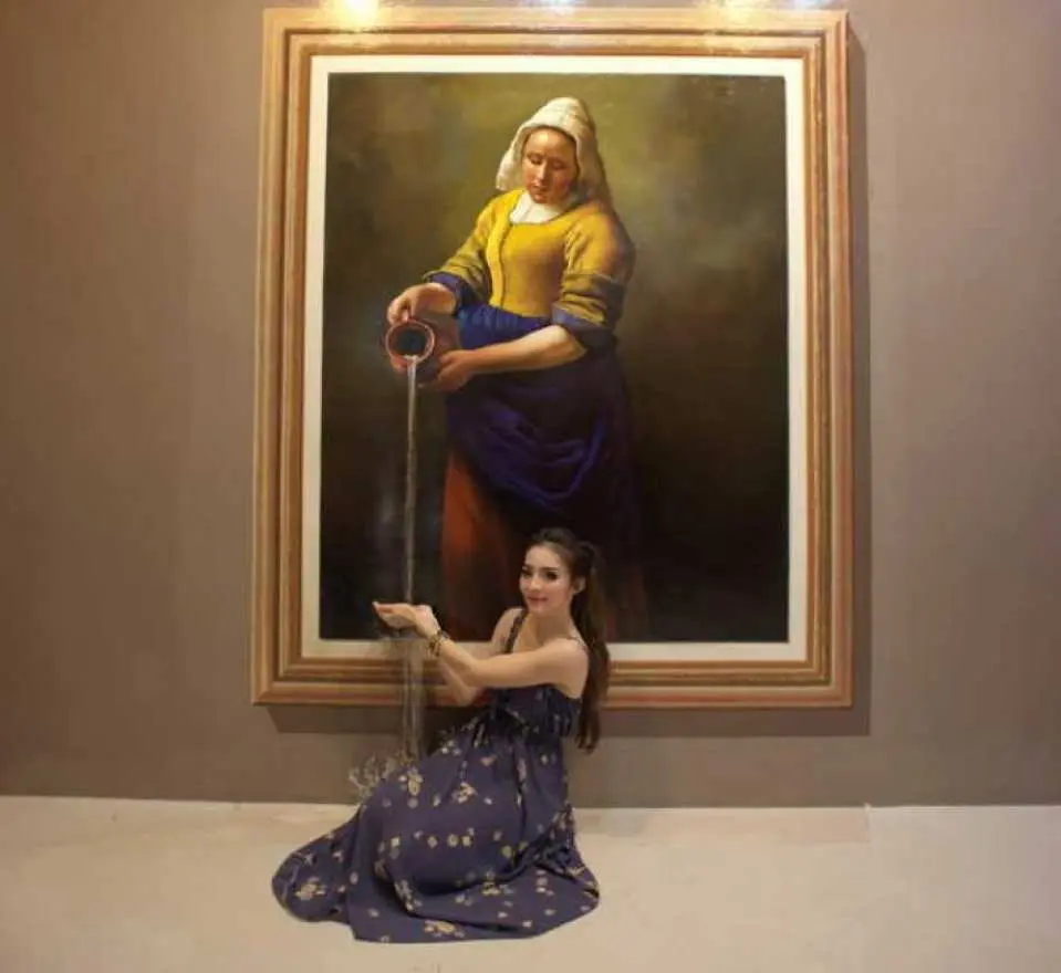 於清邁 Art In Paradise 3D 博物館，一名女子與著名畫作《倒牛奶的女僕》互動，擺拍出從畫中接取牛奶的生動場景。
