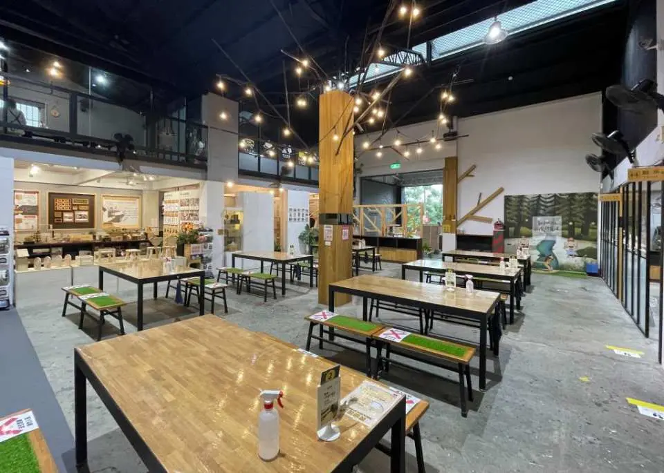 台中木匠兄妹木工房寬敞的DIY教室，擺滿木桌與長凳，為親子或團體手作實木作品提供舒適空間。