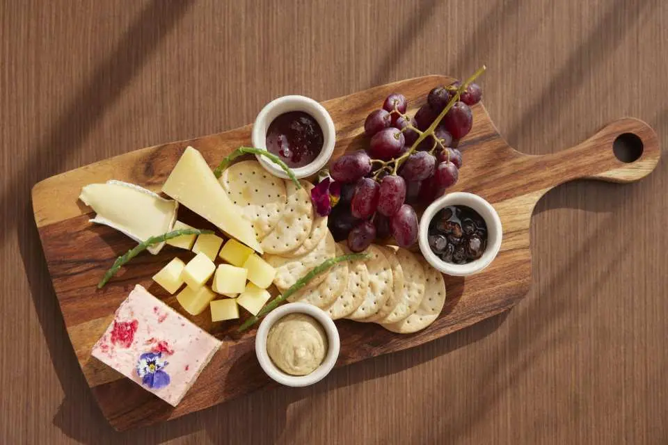 Enjoy the Australian cheese and dessert hamper featuring three types of cheese, crackers, fresh grapes, chutney, dip, and a slice infused with native flavours  (For Wintjiri Wiru After Dark package)